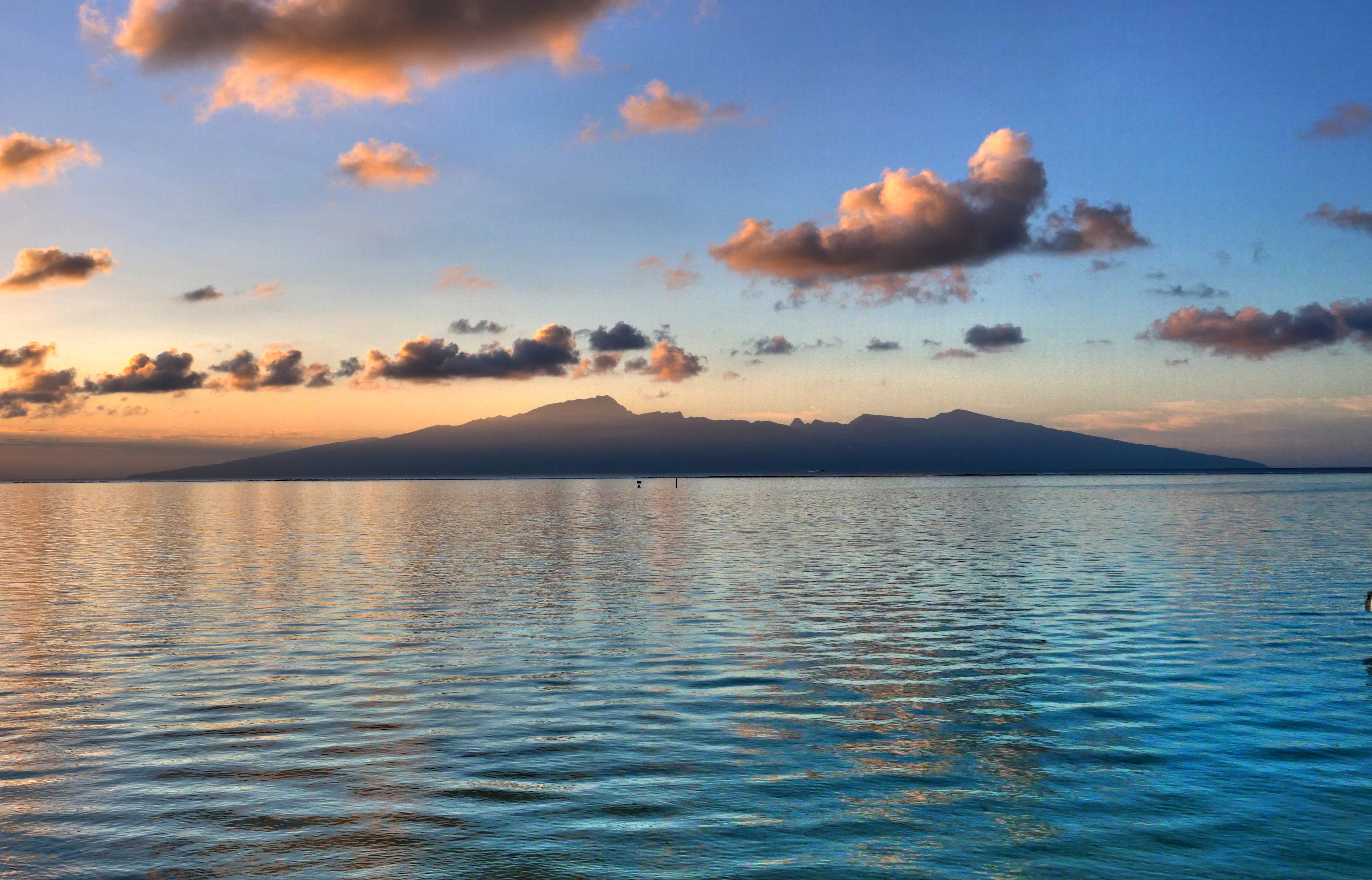 Coucher de soleil orangé et rosé sur le lagon de Taha’a, vu depuis le rivage